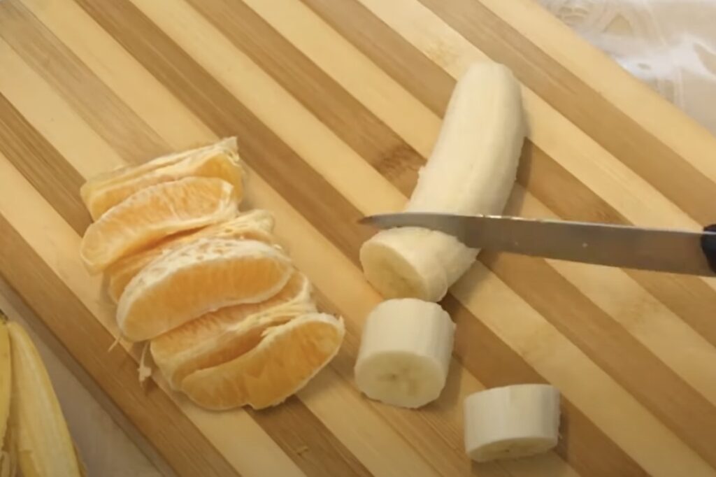 Prepare your fruits: Begin by peeling your bananas and oranges, then slice them into segments. This will make them easier to blend and ensure a smooth texture for your smoothie.